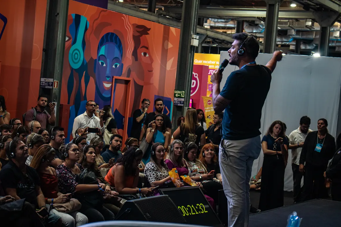 Jonathan Benitez falando para uma plateia cheia em evento de varejo